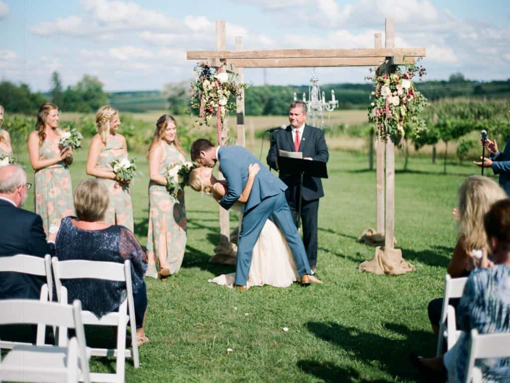 first kiss at outdoor wedding ceremony